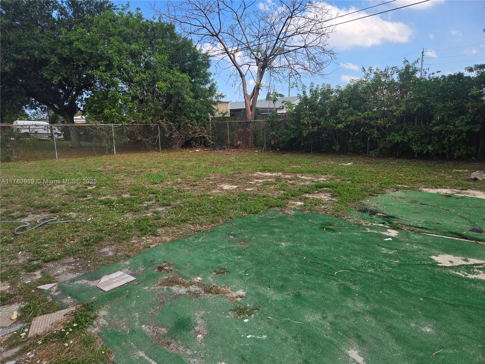 3310 Northwest 214th Street Miami Gardens, FL 33056 - Photo 17 of 17 a backyard of a house with lots of green space
