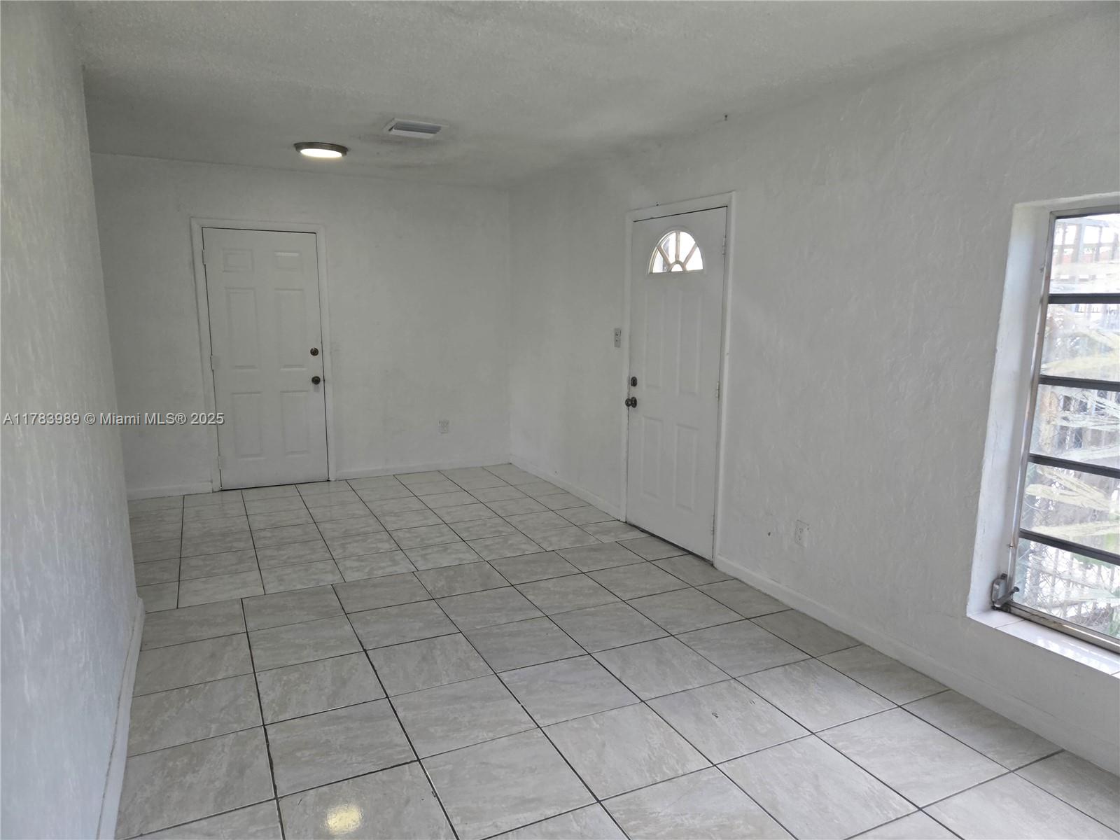 3310 Northwest 214th Street Miami Gardens, FL 33056 - Photo 3 of 17 a view of an empty room and window