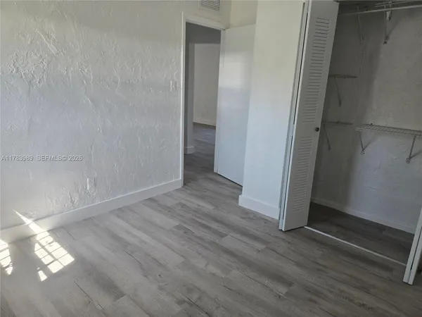 a view of a room with wooden floor