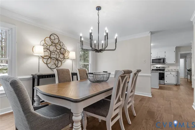 a view of a dining room with furniture a chandelier and wooden floor