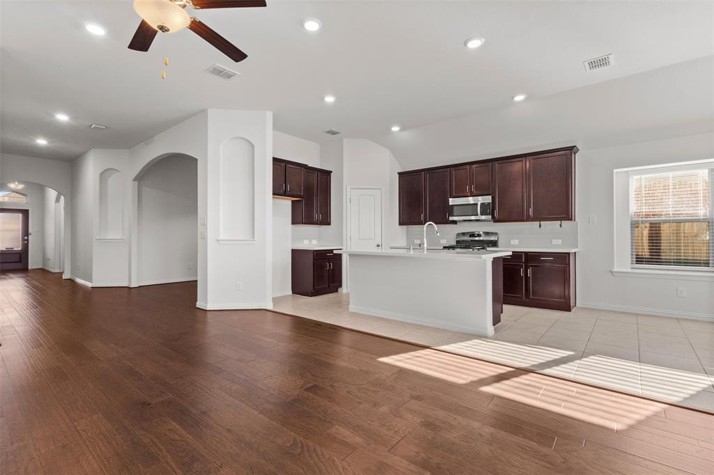 1740 Rio Costilla Road Fort Worth, TX 76131 - Photo 13 of 40 Wood-finish flooring throughout, archways, recessed lighting, ceiling fan, and kitchen island with built-in sink