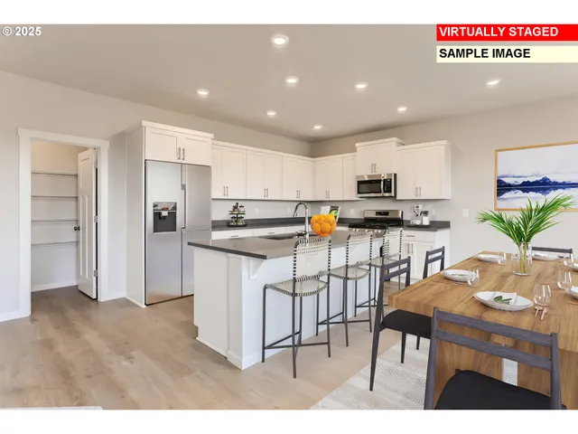 a kitchen with stainless steel appliances a refrigerator a stove a sink dishwasher and white cabinets with wooden floor