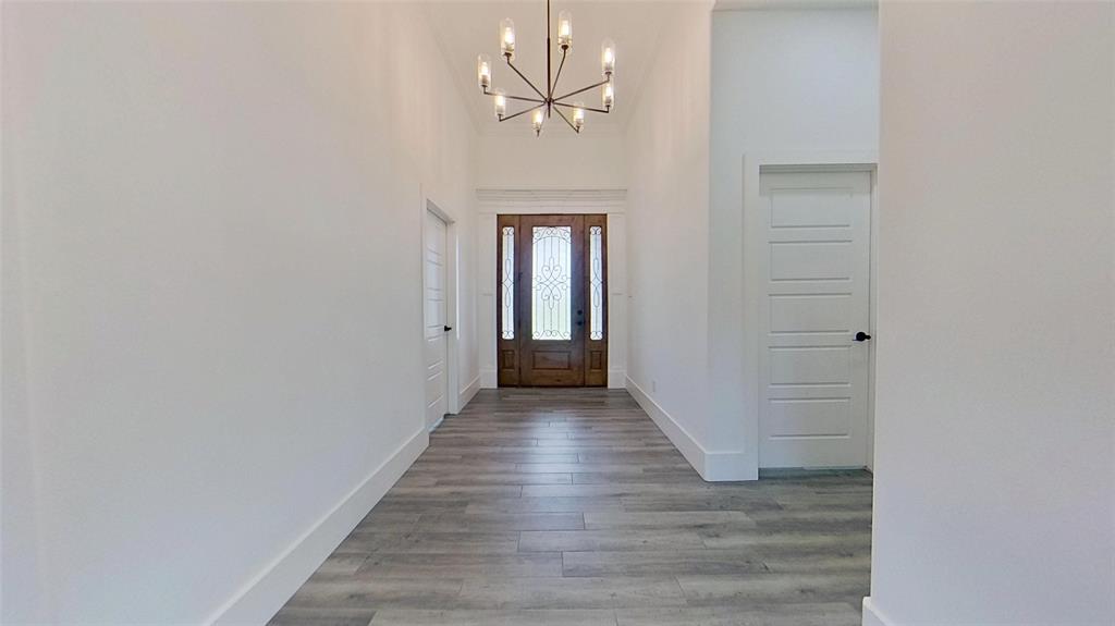 3248 North Cardinal Road Azle, TX 76020 - Photo 8 of 29 Foyer featuring a grand entrance door with decorative glass, vaulted ceiling, contemporary chandelier, and wood-finish flooring