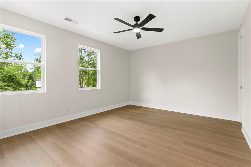 7066 Bells Way Fairburn, GA 30213 - Photo 51 of 64 a view of a big room with wooden floor and windows