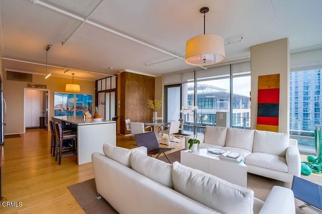 a living room with furniture a chandelier and a large window