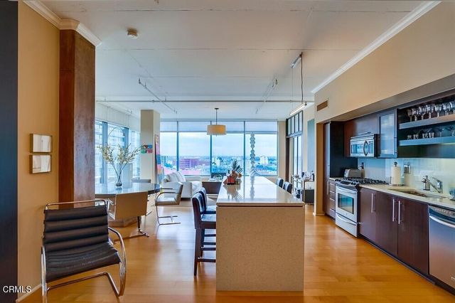 a living room with furniture large windows and wooden floor