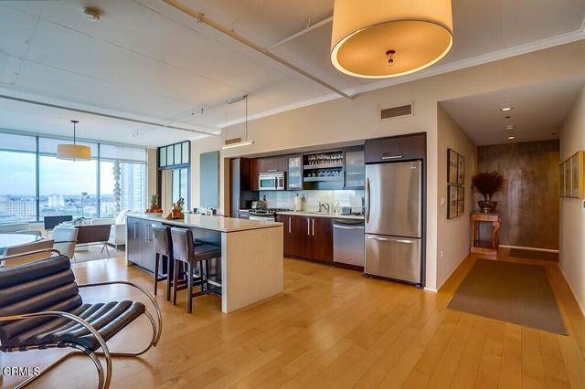 a very nice looking living room with a large window and kitchen view