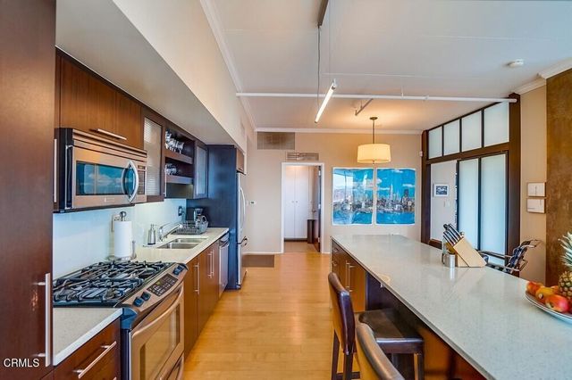 a kitchen with stainless steel appliances a stove a sink dishwasher and cabinets with wooden floor