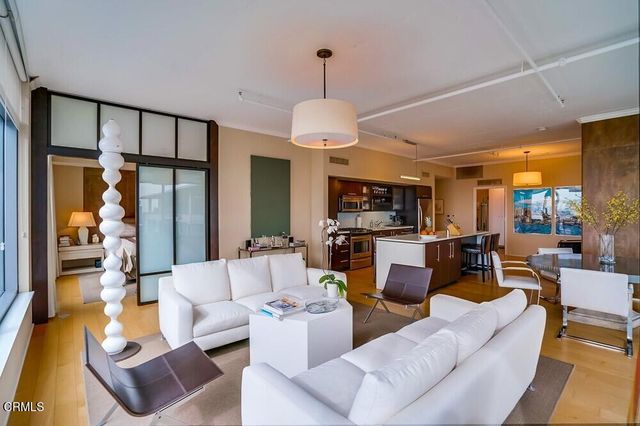 a living room with furniture a dining table and a chandelier
