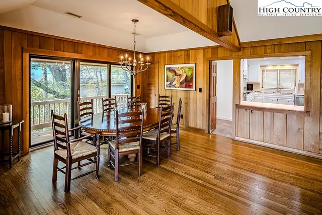 a view of a dining room with furniture a chandelier and wooden floor