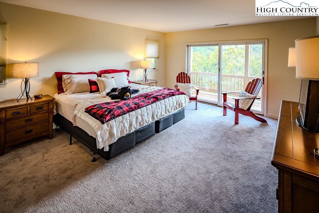 233 Balsam Road Boone, NC 28607 - Photo 35 of 50 a spacious bedroom with a bed a couch and dresser next to a window