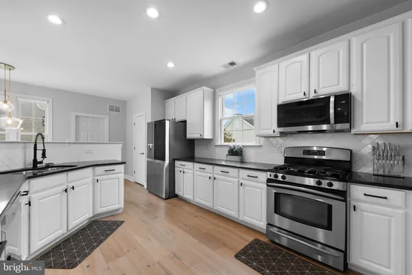 a kitchen with granite countertop a stove sink and cabinets