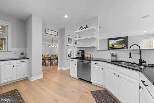 a kitchen with granite countertop a sink stove and cabinets