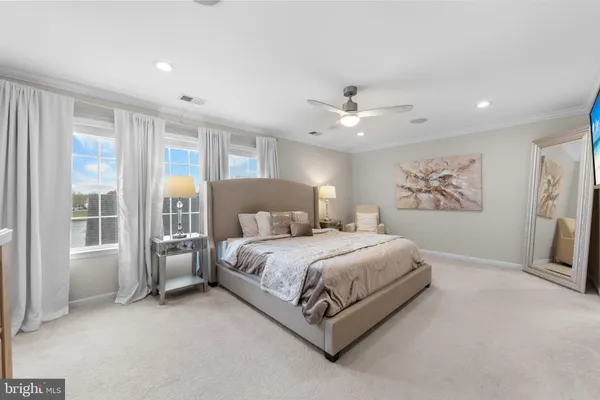 a spacious bedroom with a large bed and a chandelier