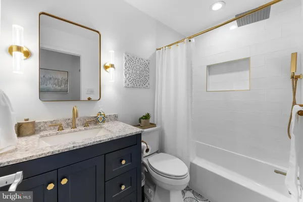 a bathroom with a granite countertop sink toilet and shower