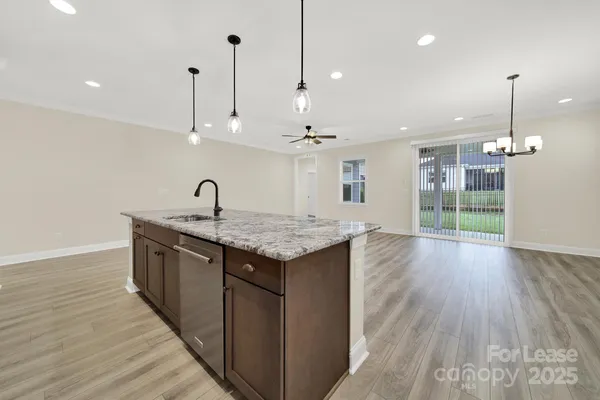 a kitchen with granite countertop a sink and a wooden floor