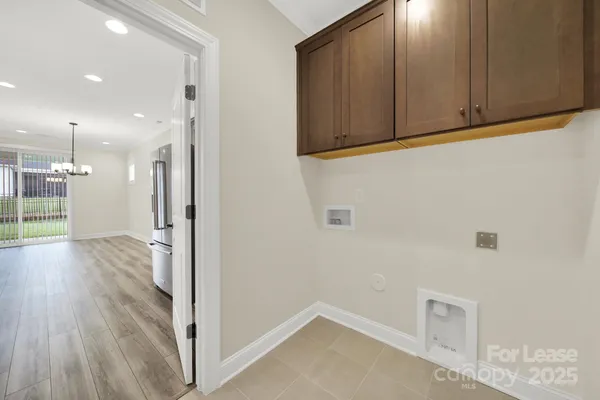 a view of a hallway with wooden floor and a cabinet