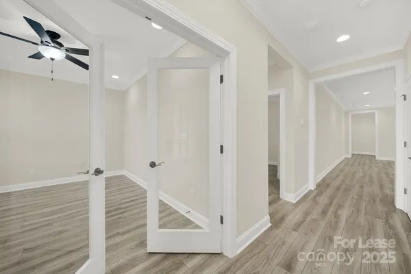 a view of a hallway with wooden floor and staircase