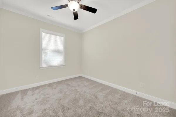 an empty room with a window and a ceiling fan