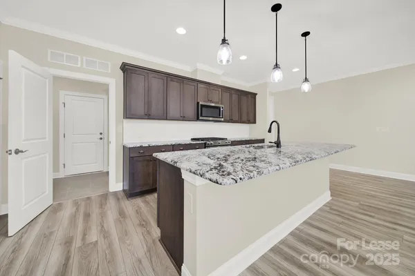 a kitchen with kitchen island a sink stainless steel appliances and cabinets