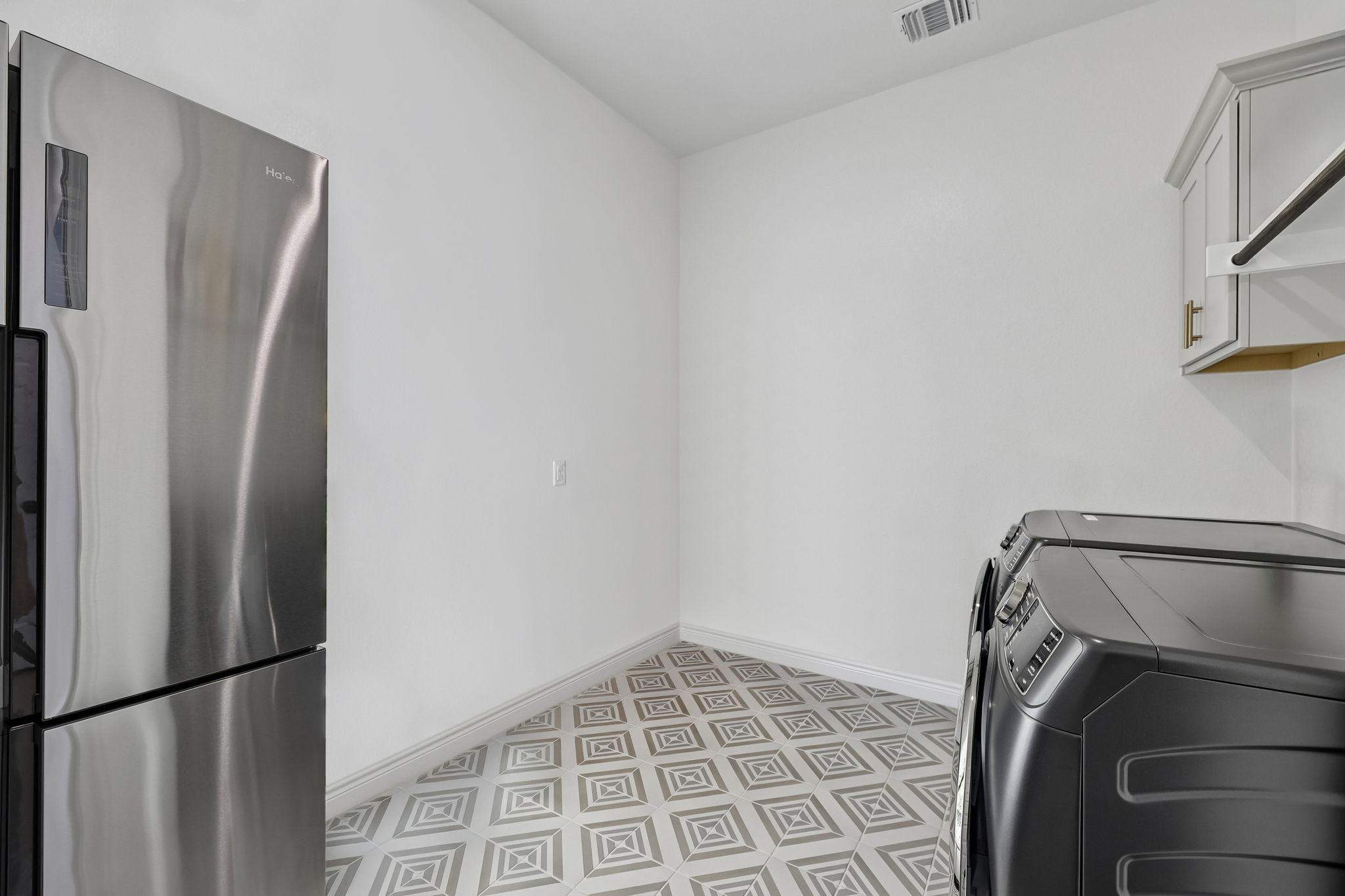 130 Firethorn Loop Bastrop, TX 78602 - Photo 24 of 38 Utility space featuring patterned floor tiling and white baseboards