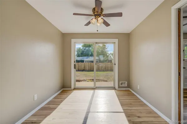 a view of a room with a ceiling fan and window
