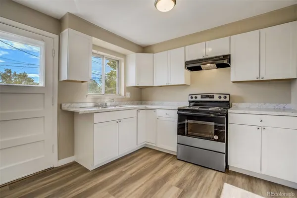 a kitchen with granite countertop white cabinets and white appliances