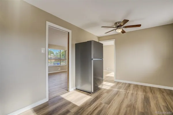 a view of empty room with wooden floor and fan