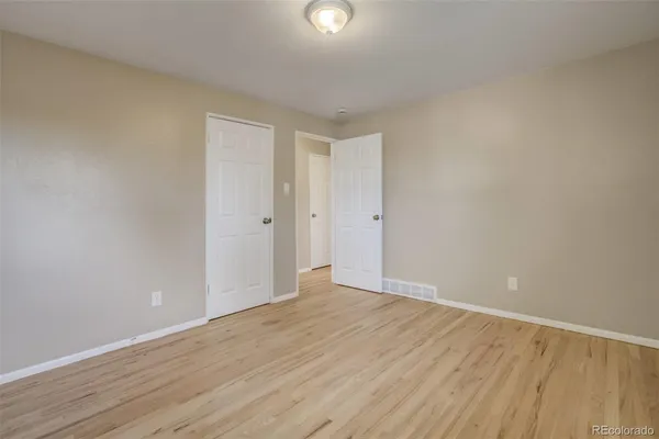 a view of an empty room with wooden floor