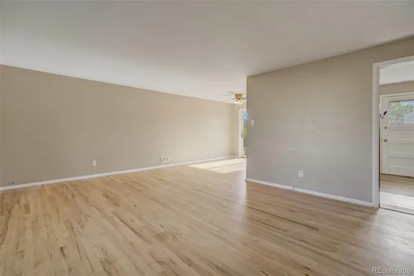 a view of an empty room with wooden floor