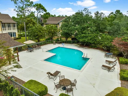 a view of a swimming pool with a patio and a yard