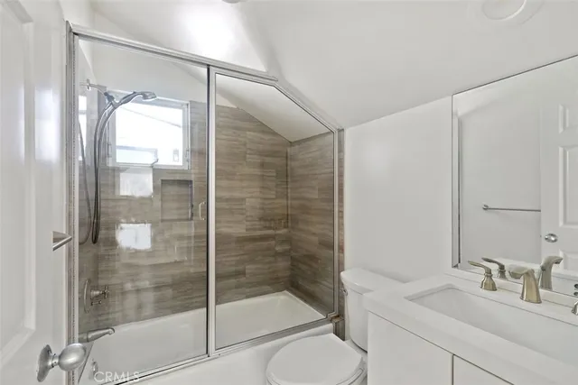 a bathroom with a shower a sink and toilet