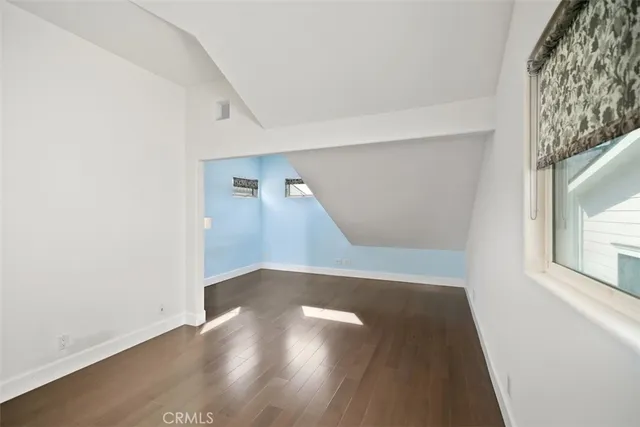 a view of a big room with wooden floor and windows