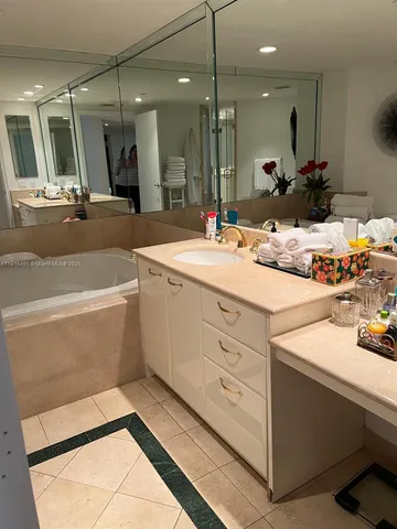 a bathroom with a sink a large mirror and a bathtub
