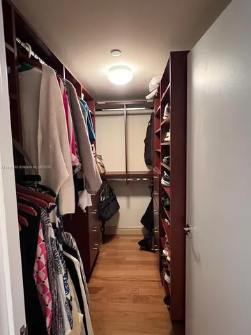 a view of walk in closet with clothes and shoes