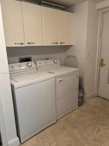a view of a storage and utility room with dryer and washer