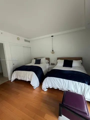 a bedroom with two beds and a lamp