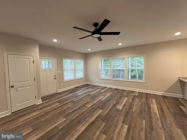 a view of an empty room with glass door and windows