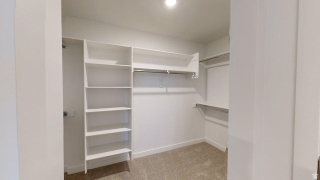 777 Pheasantbrook Drive, Unit 2B Centerville, UT 84014 - Photo 12 of 42 Walk-in closet featuring built-in shelving, multiple hanging rods, recessed ceiling lighting, and carpet flooring