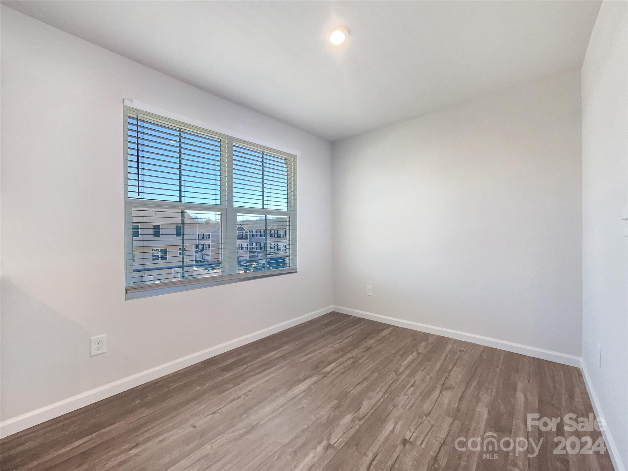 708 Dillon Way Fort Mill, SC 29715 - Photo 11 of 19 an empty room with wooden floor and windows