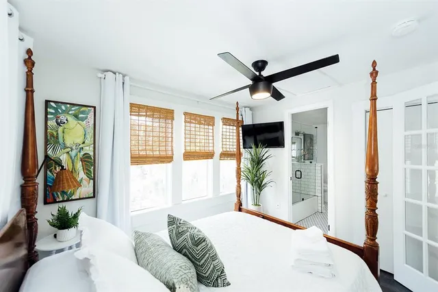 a bedroom with a bed and a potted plant