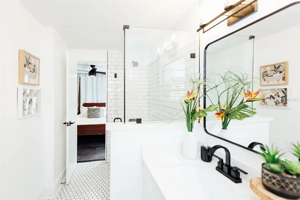 a bathroom with a shower a mirror and a sink
