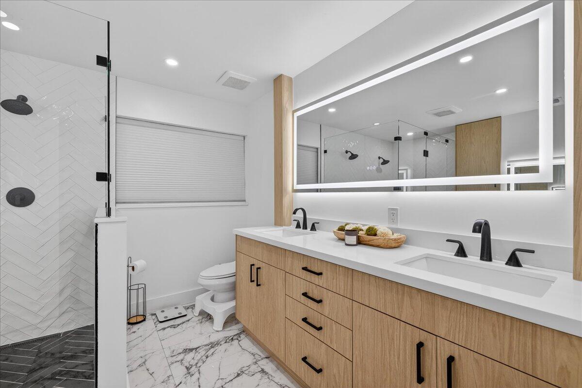 9729 North New River Canal Road, Unit 628 Plantation, FL 33324 - Photo 29 of 50 a bathroom with a granite countertop sink a toilet a mirror and shower