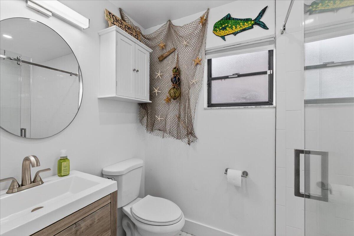 9729 North New River Canal Road, Unit 628 Plantation, FL 33324 - Photo 37 of 50 a bathroom with a sink mirror vanity and toilet