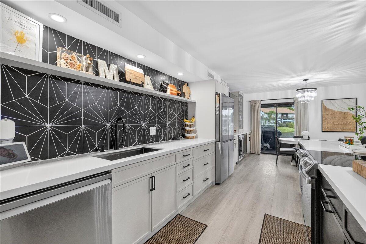 9729 North New River Canal Road, Unit 628 Plantation, FL 33324 - Photo 6 of 50 a kitchen with stainless steel appliances kitchen island granite countertop a refrigerator a stove and a sink with cabinets