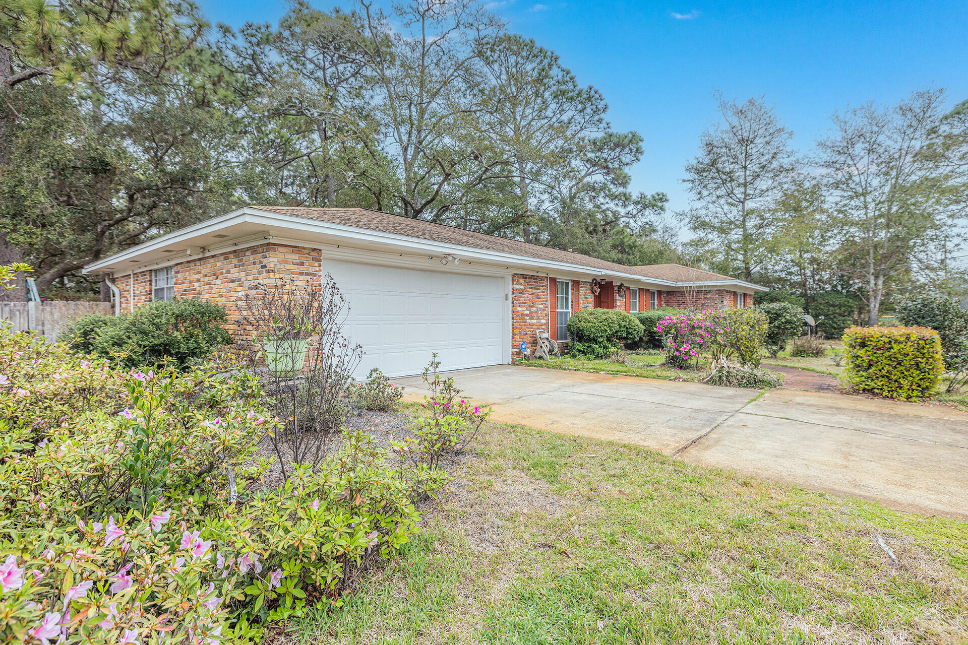 81 Country Club Road Shalimar, FL 32579 - Photo 5 of 31 a backyard of a house with plants and trees with wooden fence