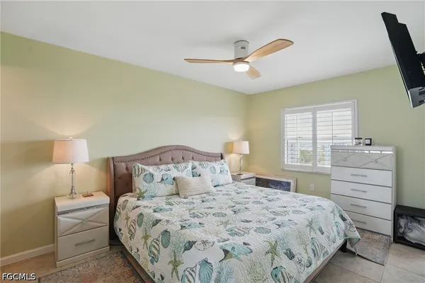 a bedroom with a bed and a flat tv screen on dresser