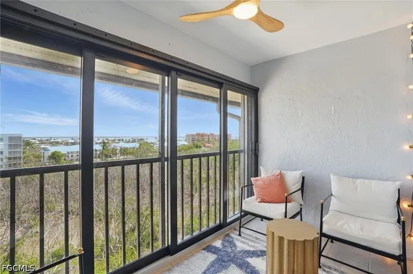 a balcony with furniture and a floor to ceiling window