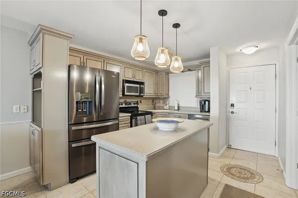 a kitchen with stainless steel appliances a refrigerator a sink a stove a microwave and island