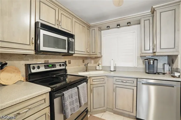 a kitchen with stainless steel appliances granite countertop a stove a sink and a microwave